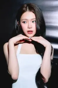 Góc nền tối có cô nàng tạo dáng tay dưới cằm, áo trắng viền đen nổi bật