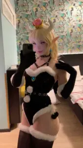 Găng tay đen và tóc vàng làm nàng thơ cosplay đứng tựa hông đầy cuốn hút