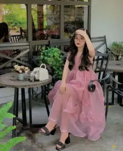 Trong quán sân vườn, dáng ngồi thảnh thơi cùng đầm hồng voan mỏng tạo nét duyên