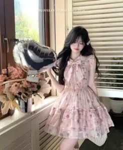 Gần khung cửa có rèm, váy hoa hồng nhạt và tóc mái đen tạo cảm giác dịu