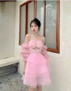 Tại góc tường, váy hồng tầng phồng kết hợp búi tóc cao làm gương mặt thanh thoát