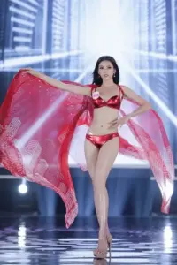Dọc sàn diễn ánh bạc, cô gái bikini đỏ dang khăn trong suốt, gương mặt điềm tĩnh