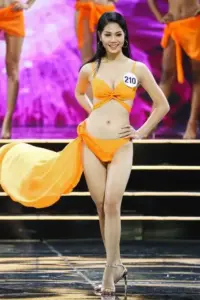 Bên cửa kính khách sạn, hoa hậu mặc bikini đen chỉnh tóc với thần thái sang