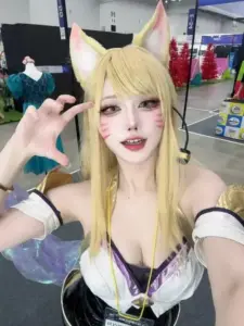 Cô nàng cosplay Leona cầm khiên vàng, đứng dưới nắng mạnh với vẻ mặt rạng rỡ như chiến binh