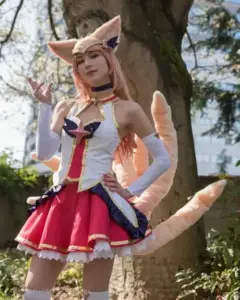 Nữ coser mặc outfit Vayne đen đỏ, đeo kính tối màu và cầm nỏ tạo dáng cực ngầu