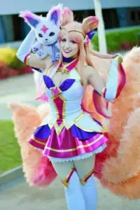 Cô nàng cosplay Xayah với lông vũ tím hồng, tạo dáng nghiêng và ánh mắt sắc đầy cá tính