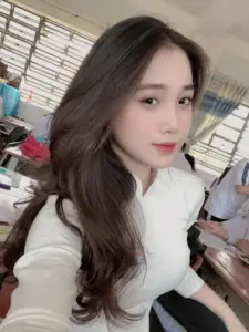 Cô gái tóc dài chụp selfie trên xe, áo trắng thanh lịch và ánh nhìn mềm mại