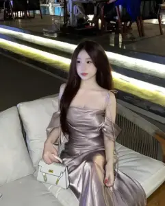 Ghế ngoài trời có cô gái duyên dáng diện váy satin nâu ngồi cầm túi trắng