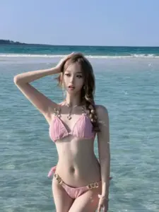 Một cô nàng buộc tóc thấp bước trên cầu gỗ, bikini kem giản dị nhìn rất dịu