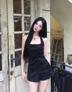 Ô cửa tạo nền cho nàng váy đen đứng bên lan can, tóc dài và mặt lạnh