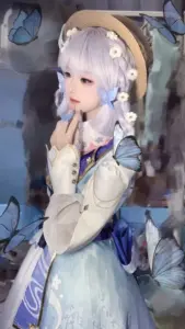 Cosplayer amber cột tóc đỏ, đeo kính phi công trên đầu và mỉm cười giữa đồng cỏ xanh