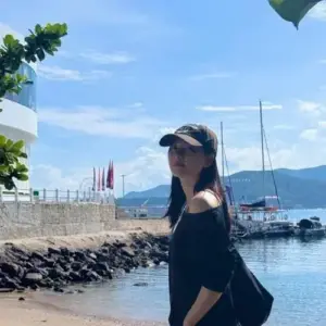 Nắng cảng biển phủ lên mũ lưỡi trai đen, áo khoác tối màu và dáng quay lưng