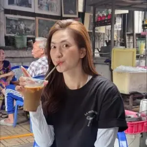 Ở quán vỉa hè, cô chu môi bên ly trà sữa với mái tóc nâu buông mềm