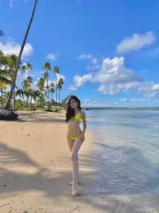 Với ánh sáng studio mềm, cô gái diện bikini trắng, tóc thẳng xõa vai và cười nhẹ