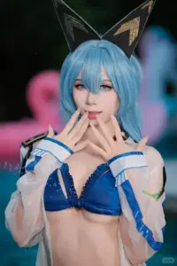Nàng cosplay anime tóc vàng buộc hai bên, nở nụ cười tinh nghịch trong bộ bikini cam