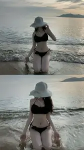Chiếc mũ rộng vành che mặt khi cô gái đứng trước sóng, bikini đen tạo dáng gọn gàng