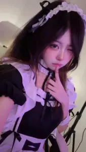 Ánh tím tối phủ lên cô maid đội mũ ren, ngón tay đặt nhẹ trước môi