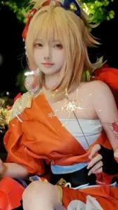 Nàng ayaka mặc kimono xanh đứng dưới tán hoa anh đào, dáng nghiêng nhẹ tạo cảm giác thanh lịch