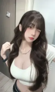Làn tóc xoăn buông vai giúp kiều nữ áo trắng cổ sâu trông dịu mà quyến rũ.