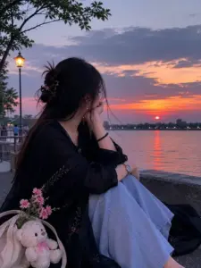 Cô nàng mặc áo sơ mi trắng quay sau, tay chỉnh tóc tạo dáng tự nhiên trước cửa kính