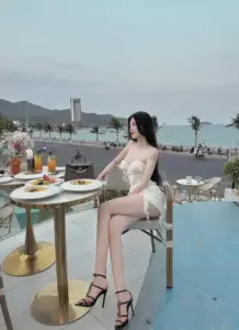 Bàn tiệc sát biển làm nổi bật cô gái váy trắng, chân dài, sandal đen thanh mảnh