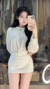 Chiếc váy trắng dài tay ôm sát giúp bóng hồng selfie trước gương trông thanh thoát