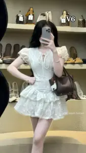 Gương phòng ăn phản chiếu hot girl diện váy ngắn chống eo, che mặt bằng điện thoại