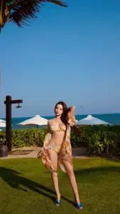 Nắng biển chiếu qua khu vườn, cô nàng bikini họa tiết tạo dáng bên lan can