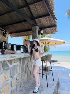Góc quầy bar ven biển ghi lại cô gái bikini sáng màu đứng khoe dáng tự nhiên