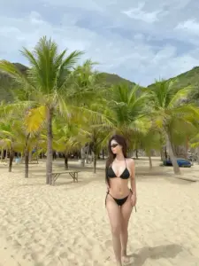 Trên bãi cát rộng cô nàng bikini đen đứng giữa hàng dừa trong nắng dịu