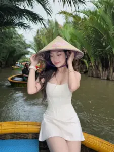 Con thuyền nhỏ giữa rặng dừa tạo nền cho nàng váy trắng đội nón lá thư thái