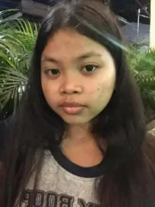 Gương mặt nhìn thẳng dưới ánh tối, tóc dài xõa tự nhiên tạo cảm giác ảnh đời thường