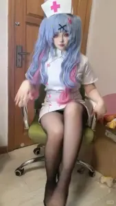 Trên ghế xoay gỗ, cô gái tóc xanh diện cosplay y tá trắng cùng tất đen