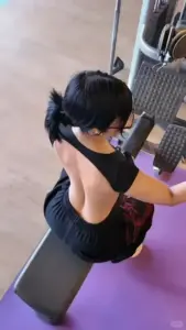Từ góc chụp cao, cô gái áo đen ngồi cúi nhẹ, phong cách đáng yêu đời thường