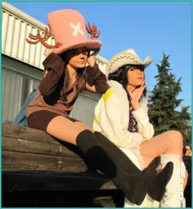 Coser tóc hồng cosplay Shirahoshi ngồi bên hồ nước, váy dài mềm và biểu cảm trong trẻo như nàng tiên cá