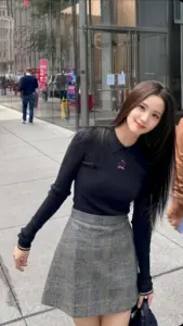 Ngoài phố kính sáng, nàng thơ Dior cười nhẹ với áo đen ôm và chân váy xám