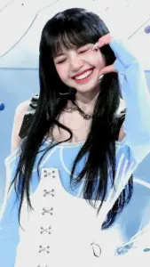Nữ idol cười rạng rỡ với áo trắng ôm dáng, tay giơ ký hiệu dễ thương