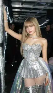 Lisa trong váy bạc lấp lánh giơ tay tạo dáng, ánh đèn tối làm visual thêm sang