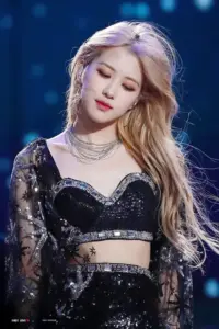 Trên sân khấu xanh, nữ idol tóc vàng nhắm mắt dịu dàng, diện outfit đen lấp lánh rất cuốn