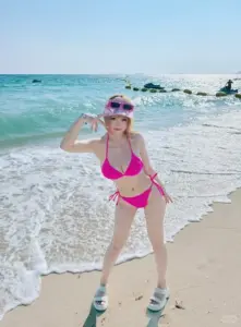 Giữa ban công khách sạn, cô gái bikini cam tựa tay lan can, mắt cười nhìn nắng