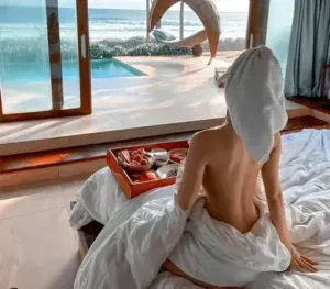 Bối cảnh hồ bơi hiện đại nhấn vào vai trần, tóc xoăn và dáng đứng thoải mái