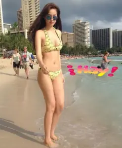 Dưới nắng biển, cô gái bikini vàng bước tự tin, kính râm tạo vẻ ngoài nổi bật