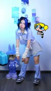 Toàn thân mỹ nhân anime diện bộ tím, giày trắng và tóc xanh tạo dáng sân khấu