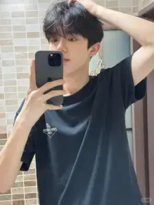 Trước gương, gương mặt học trò mặc áo đen, tay vuốt tóc và đeo khuyên nhỏ