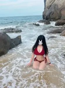 Trong làn sóng sát ghềnh đá, bikini đỏ tạo điểm nhấn bắt mắt trên nền biển xám
