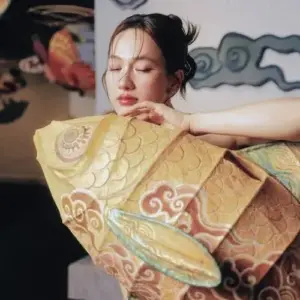 Bộ trang phục vàng họa tiết ôm lấy dáng nghỉ ngơi, hàng mi nhắm nhẹ rất mềm