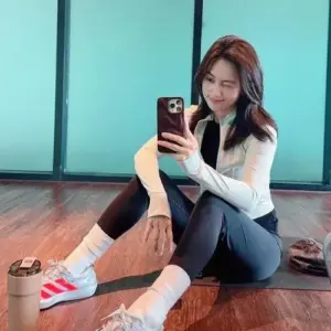 Cửa kính tầng cao phản chiếu tấm selfie, áo trắng và sneaker đỏ tạo vẻ năng động