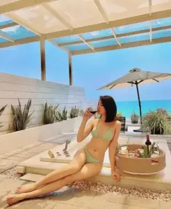 Góc nghiêng trên ghế nghỉ làm đồ bơi xanh nhạt và làn da sáng trông hài hòa