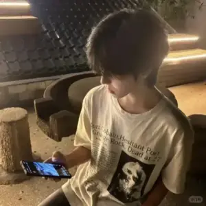 Không gian quán bar tối làm nổi áo sơ mi đen, đồng hồ bạc dáng tựa bàn