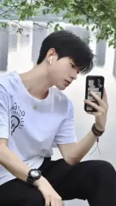 Góc selfie nghiêng bên hành lang sáng, áo thun trắng làm nổi bật mái tóc đen gọn